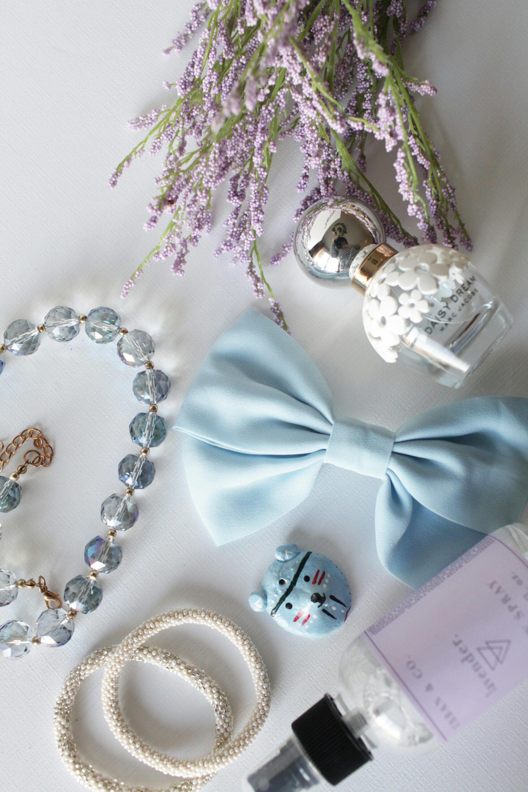 Home Flat lay of lavender, bow, jewelry, and perfume creating an elegant arrangement on a white background.