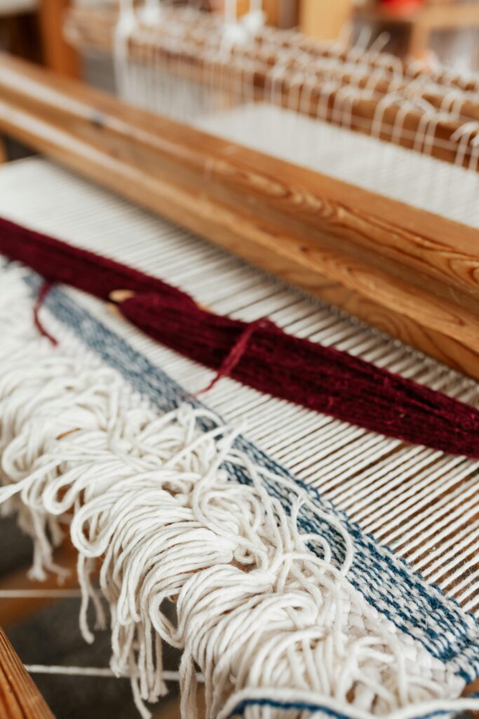 Close-up of a handwoven textile on a loom in an artisan workshop, showcasing traditional craftsmanship.