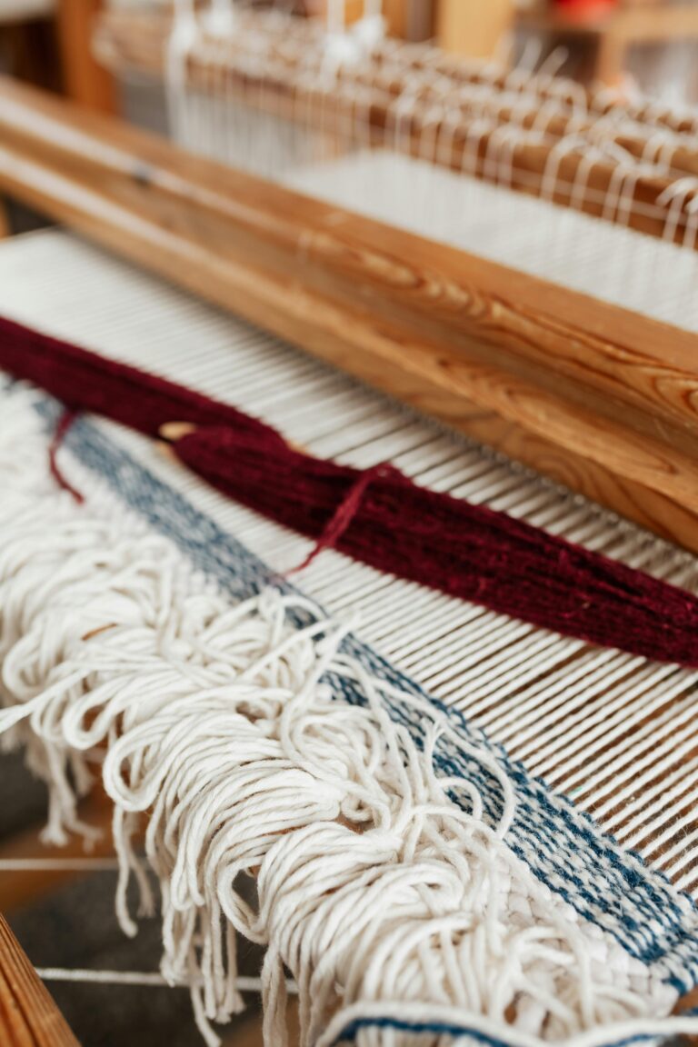 Close-up of a handwoven textile on a loom in an artisan workshop, showcasing traditional craftsmanship.